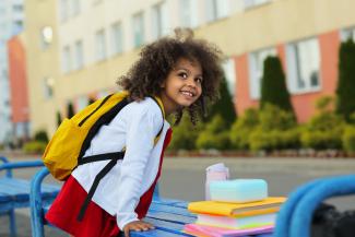 Child waiting to be picked up outside of school